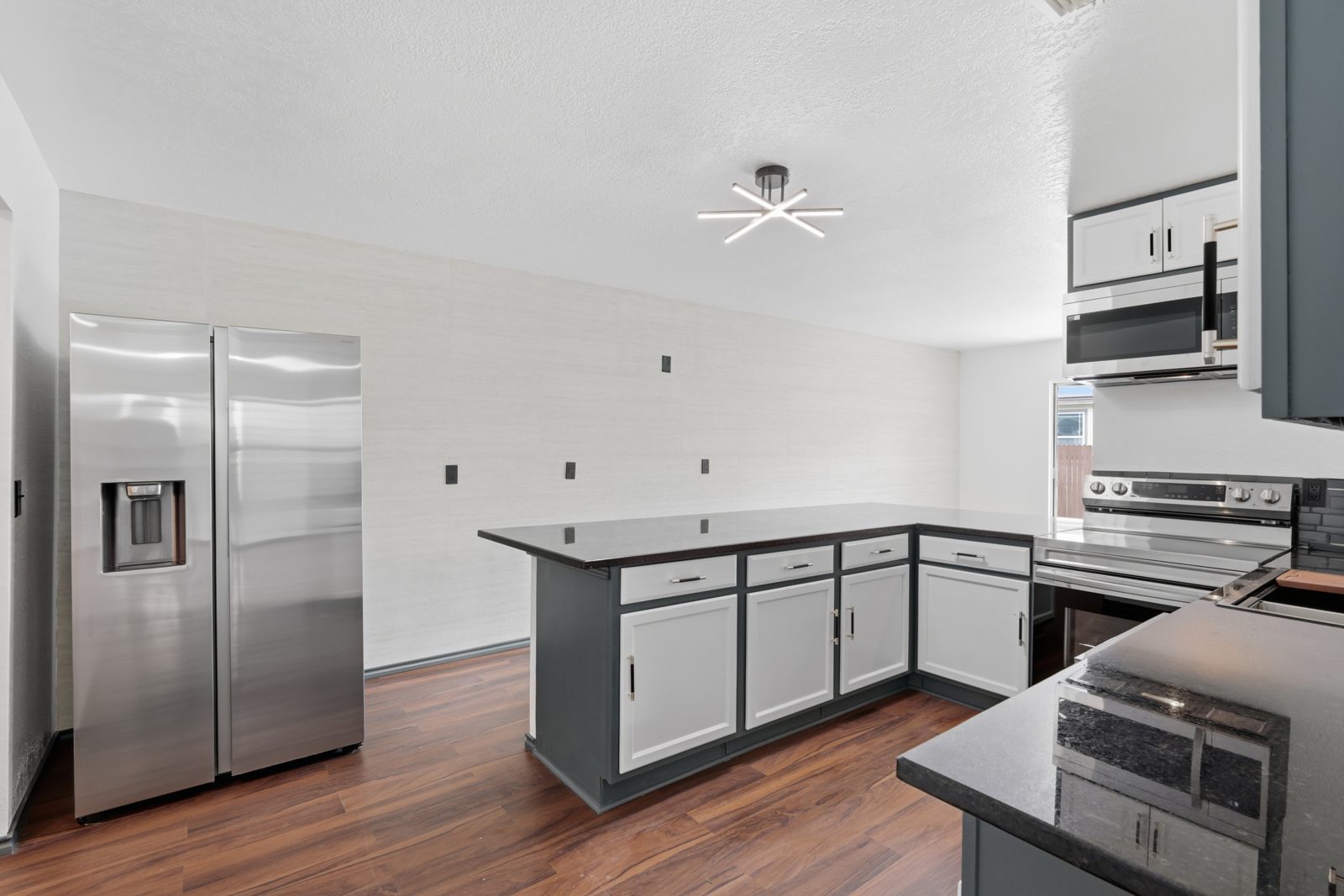 Remodeled kitchen with white cabinets, quartz counters, and stainless appliances